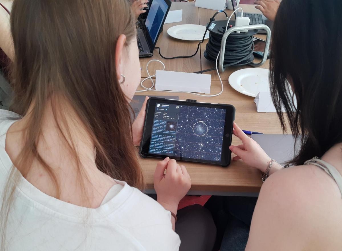 Two students from Mathilde Anneke School use a tablet to locate the dwarf galaxy Caldwell 57 in the constellation Sagittarius.