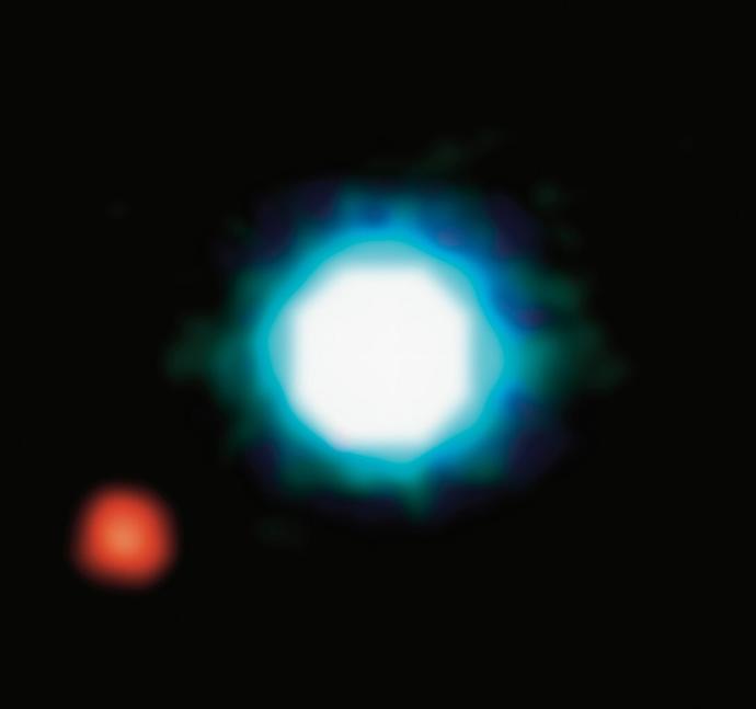 A large, blue sphere is in the centre of the image against a black background. There is a fuzzy glow around it. In the lower left corner there is a smaller, red sphere.
