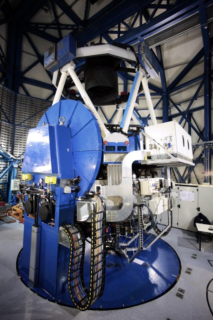 A 2.6-metre telescope, pointing upwards, inside its enclosure.