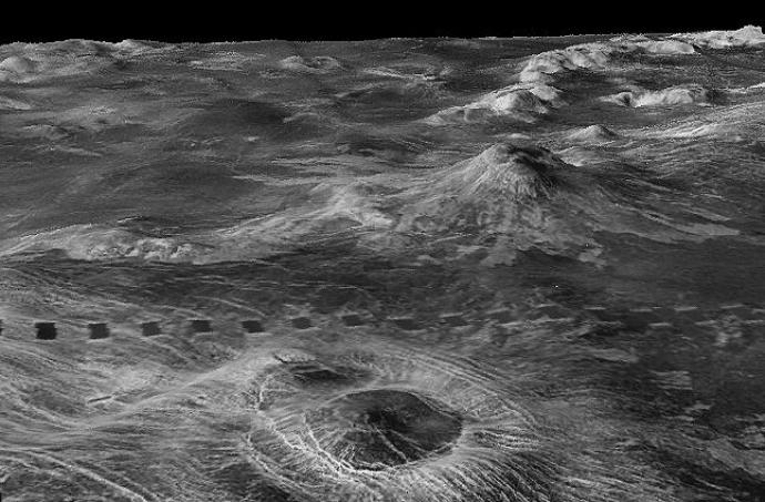 Black and white radar image of Venus' surface showing rugged terrain with mountains, craters, and valleys